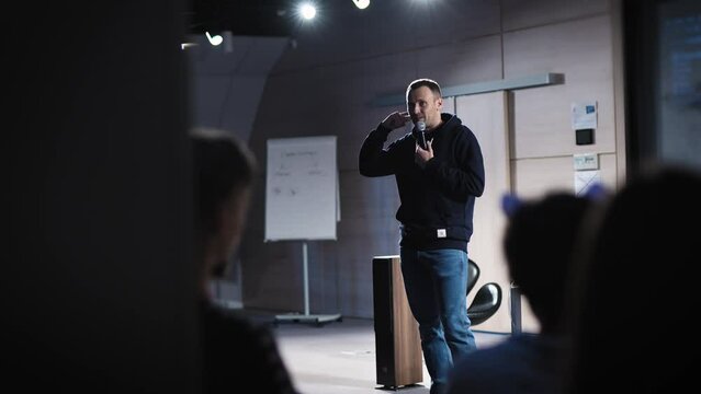 Conference in the IT industry. A young and successful male speaker talks about modern solutions to students and colleagues.