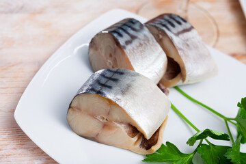 Closeup slices of slightly salted herring with parsley. High quality photo