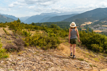 Naklejka na ściany i meble A woman on a trek between the villages of Las Latas to Larrede near Sabiñanigo, Pyrenees aragon