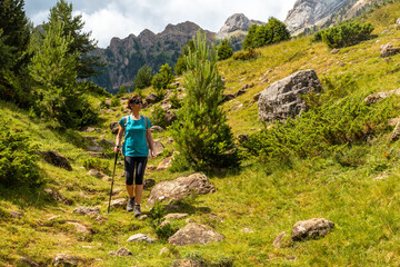 Fototapeta na wymiar A young woman on the trek going up the mountain to the Piedrafita arch in the Pyrenees in Panticosa, Aragon