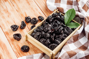 delicious dried prunes on a wooden rustic background