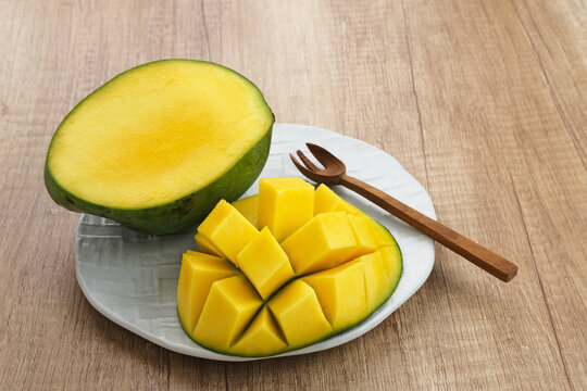 Fresh and ripe mango fruit on wooden background. Close up.
