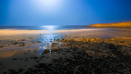 Beautiful seascape with a reflection of moon lights by night in Imesouane Morocco