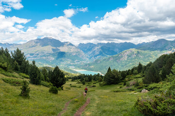 Fototapeta na wymiar A woman trekking towards Ibon de Piedrafita, Tena valley in the Pyrenees, Huesca, Spain