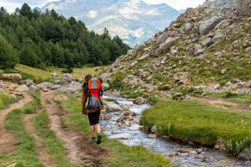 Woman with her son in the backpack walking in the Pyrenees, Valle de Tena, Huesca