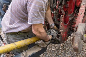 Agriculteur fixant un cardan de prise de force sans capuchon de protection de sécurité sur un tracteur