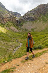 A young woman next to the Salto de Tendenera Waterfall in the Ripera Valley, Panticosa, Pyrenees