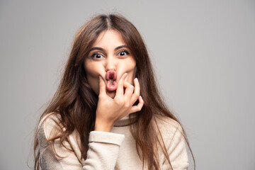 Young beautiful woman holding mouth and lips shut as zip with fingers © rastockinc