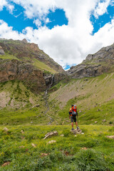 Fototapeta na wymiar A young man visiting the Salto de Tendenera Waterfall in the Pyrenees in the Ripera Valley, Huesca