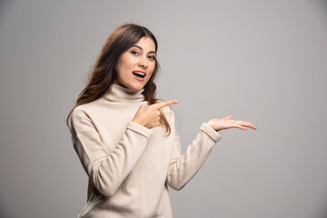 Young woman holding copy space imaginary on the palm to insert an ad