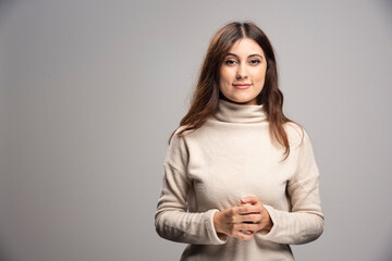 Fototapeta premium Portrait of a young woman posing on a gray wall