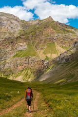 Fototapeta premium A young man enjoying freedom in the mountains in the Ripera valley in summer, Pyrenees