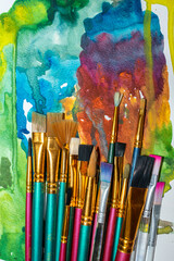 brushes for painting on a background of bright watercolor abstraction