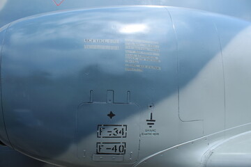 instructions on the body of a military aircraft on a faded blue background.