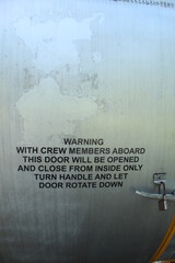 instructions on the body of a military aircraft on a faded blue background.