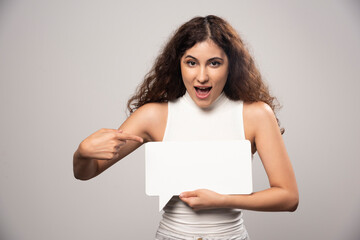 Young woman holding empty blank white speech poster