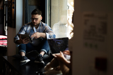 Young businessman using digital tablet in the office. Handsome man learning online.