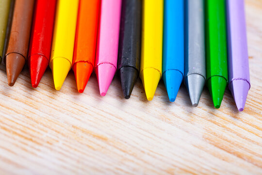 Picture of multicolored pastel pencils on wooden background