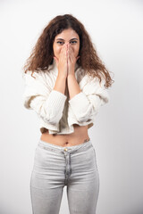 Young woman in white sweater with curly hair posing