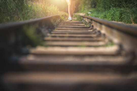 Closeup of a person walking on the railway on a sunny day - new opportunities