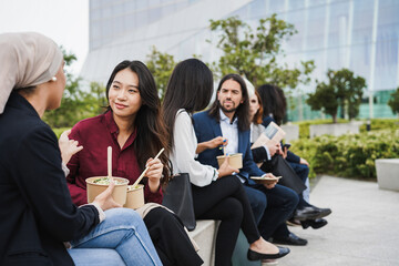 Multiethnic business people doing lunch break outdoor from office building - Focus on asian girl...