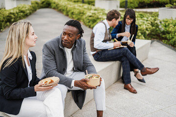 Multiethnic business people doing lunch break outdoor from office building - Focus on african man...