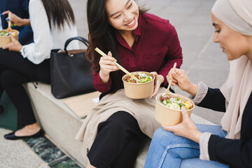 Multiracial business people doing lunch break outdoor from office building - Focus on asian woman...
