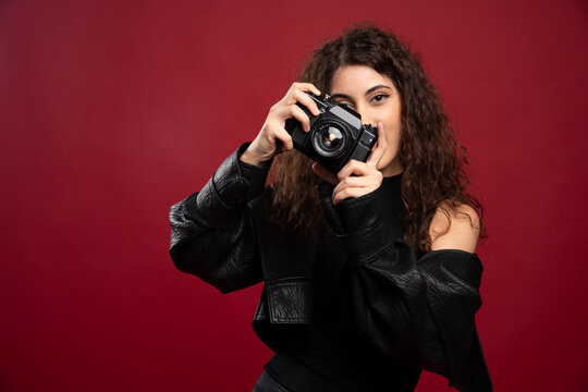 Woman photographer in all black outfit taking pictures with a camera