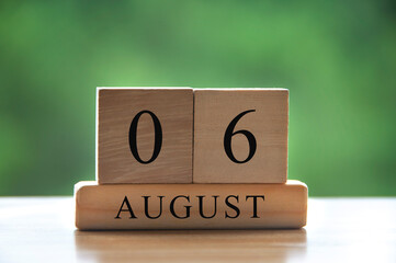August 6 calendar date text on wooden blocks with blurred background park. Copy space and calendar concept