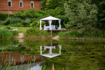 white wedding pavilion altar next to a small lake