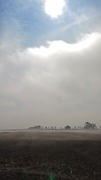 Morning misty fog above fields, clouds in the sky, vertical video
