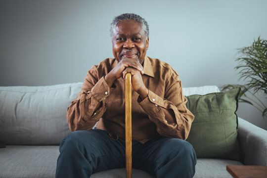 Portrait of happy senior man sitting at home with walking stock and smiling. Portrait of happy senior man sitting at home with walking stock and smiling. 