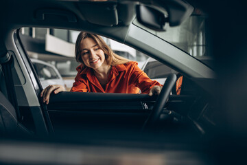Woman choosing a car in a car showroom
