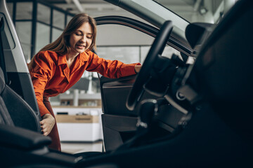 Woman choosing a car in a car showroom