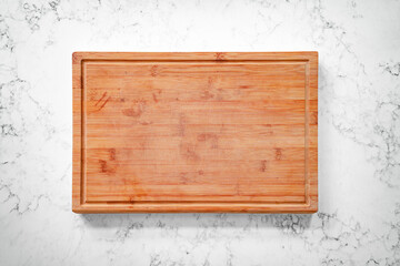 Wooden cutting board on a marble counter top