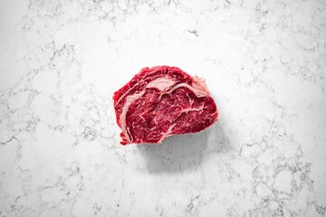 Cut of rib-eye steak on a marble counter top