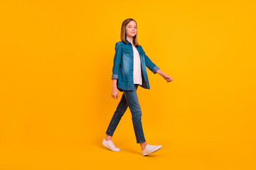 Fototapeta na wymiar Full length profile photo of nice adorable girl walking have good mood isolated on yellow color background