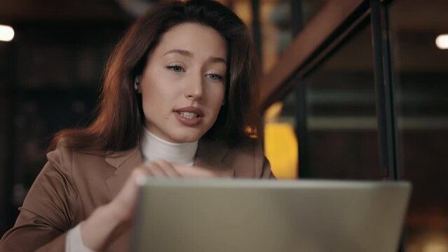 Young business lady discussing project with colleagues on online meetup. Elegant business woman emotionaly gives instructions to subordinates at cafe . Business concept