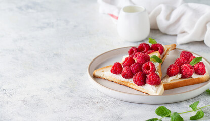 Toast with raspberries on a plate, copy space