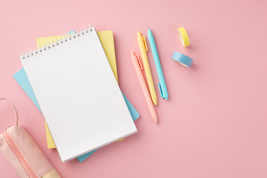 Back to school concept. Top view photo of school supplies open spiral notepad colorful pens pencil-case and adhesive tape on isolated pink background with blank space