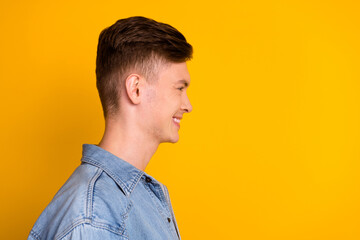 Profile side photo of young cheerful guy good mood look empty space isolated over yellow color background