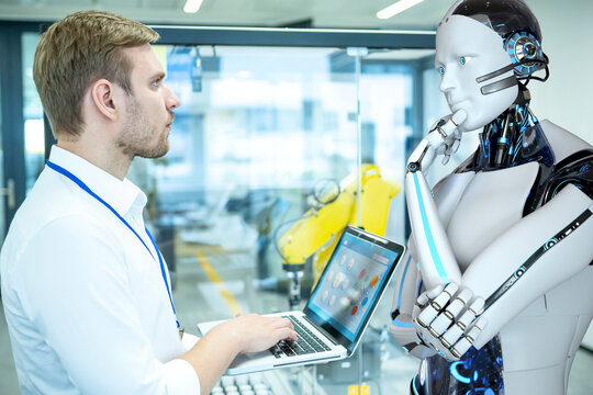 Humanoider Roboter unterst&uuml;tzt einen IT-Ingenieur bei der Entwicklung der Industrieroboter