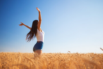 Happy woman enjoying the life in the field. Nature beauty, blue sky, white clouds and field with golden wheat. Outdoor lifestyle. Freedom concept. Woman jump in summer field - 515361478