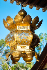 Beautiful golden lantern detail hanging from the roof at the Poet's Festival, Kitano Tenmangu Sanctuary in Kyoto, Japan.