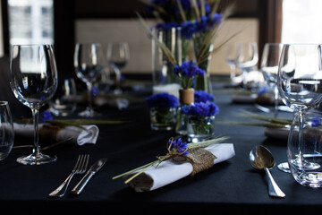 A set of furniture in a cafe. Vase with flowers decor for the restaurant. Black tablecloth