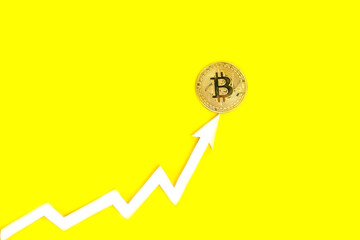 Arrow graph indicates growth of value bitcoin cryptocurrency,on yellow background.