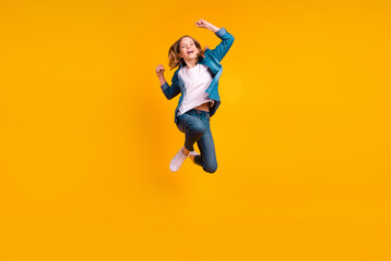Obraz premium Full length portrait of overjoyed delighted girl raise fists celebrate achievement jumping isolated on yellow color background