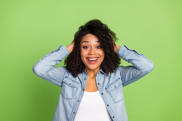 Photo of young excited pretty woman hands touch cheeks haircare curls isolated over green color background