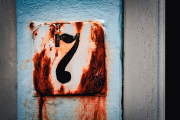 Liczba siedem. Stara zardzewiała tabliczka na drzwi z numerem domu.