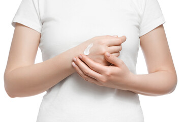 Cropped shot of a woman in white t-shirt applying hand cream, isolated on white. Well-groomed short natural nails.